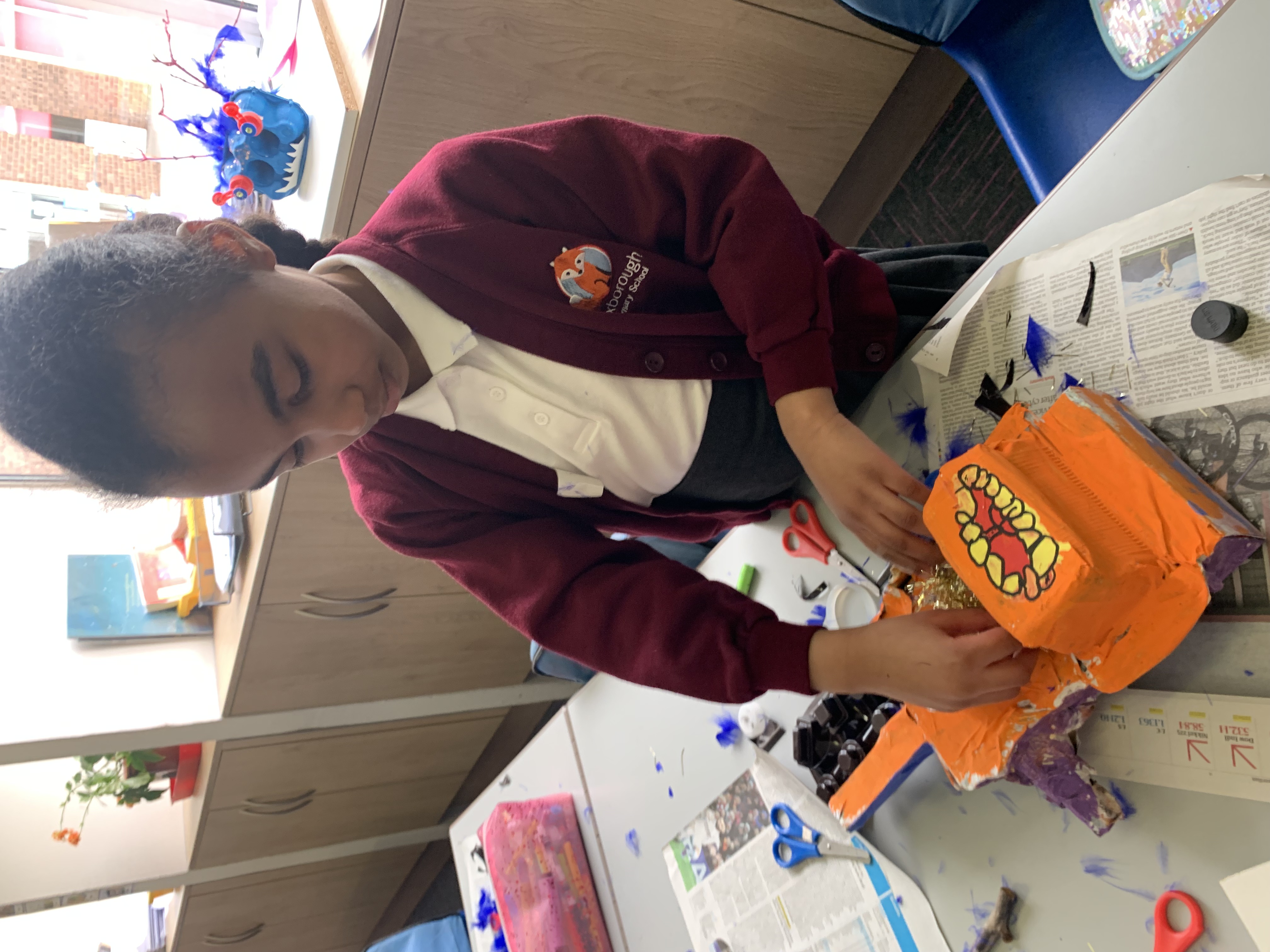 Schoolchildren decorate their paper mache models